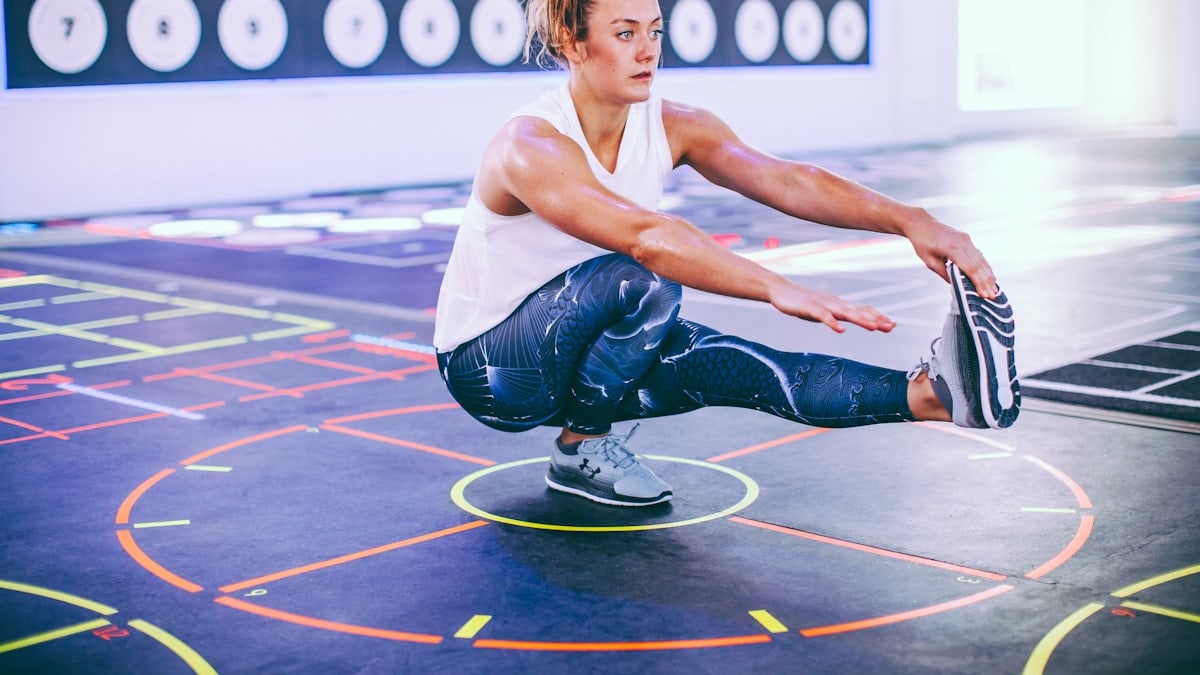 Woman doing pistol squats with floor markings in Prama