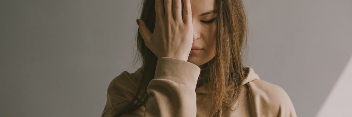 a woman covering her face with her hands